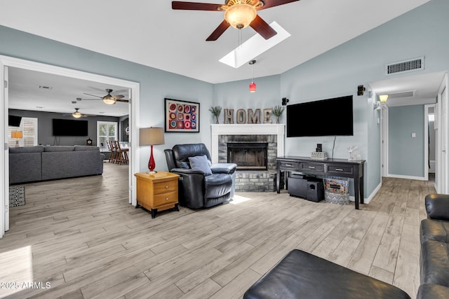 4116 E Downing St, Mesa, AZ 85205 - living room with ceiling fan, a fireplace, light wood-style flooring, a skylight, and lofted ceiling