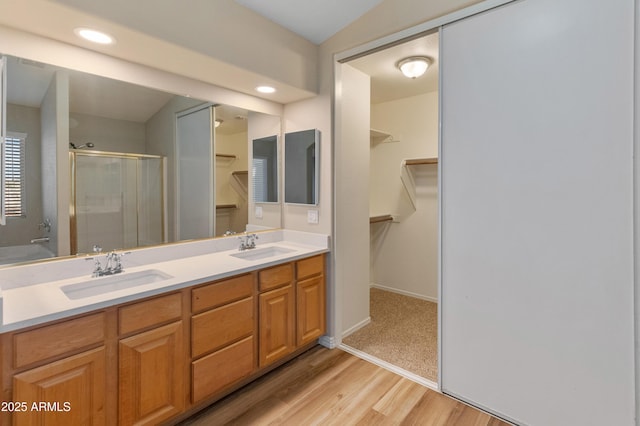 bathroom featuring a shower with door, wood-type flooring, and vanity