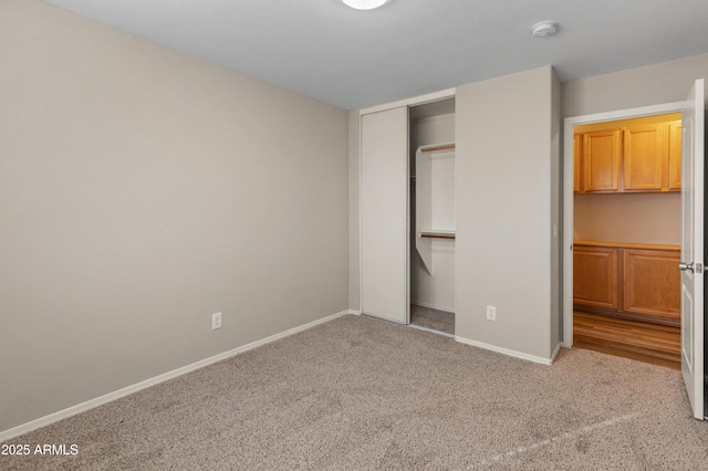 unfurnished bedroom featuring light colored carpet and a closet