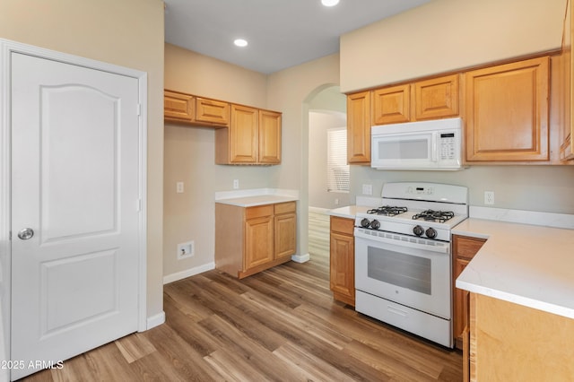 kitchen featuring white appliances and light hardwood / wood-style flooring