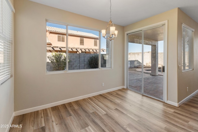 unfurnished dining area featuring hardwood / wood-style flooring and a notable chandelier