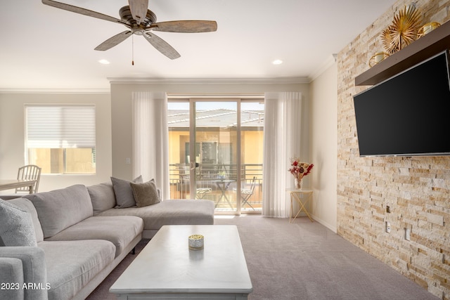 carpeted living room with ornamental molding and ceiling fan