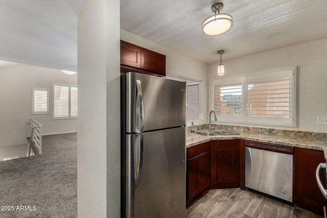 154 W 5th St Unit 210, Tempe, AZ 85281 - kitchen featuring appliances with stainless steel finishes, light stone countertops, pendant lighting, and light wood-type flooring