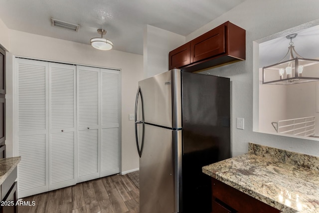 154 W 5th St Unit 210, Tempe, AZ 85281 - kitchen featuring freestanding refrigerator, a chandelier, wood finished floors, light stone countertops, and decorative light fixtures