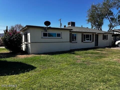 rear view of house featuring a yard