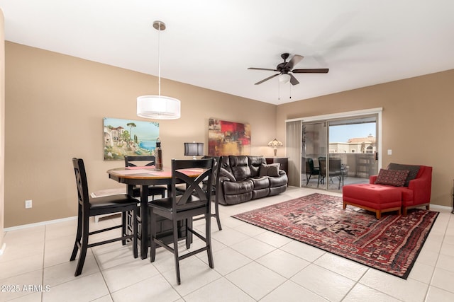 dining space featuring light tile patterned flooring, a ceiling fan, and baseboards