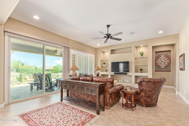 tiled living room with ceiling fan and built in features