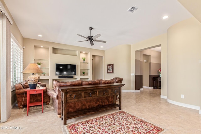 living room with ceiling fan, built in features, and light tile patterned floors