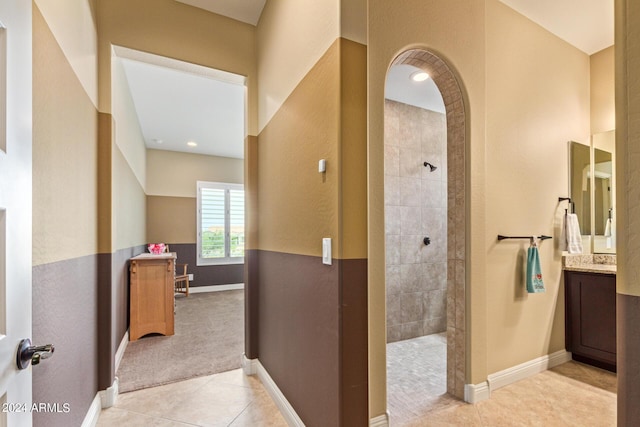 bathroom with tiled shower, vanity, and tile patterned floors