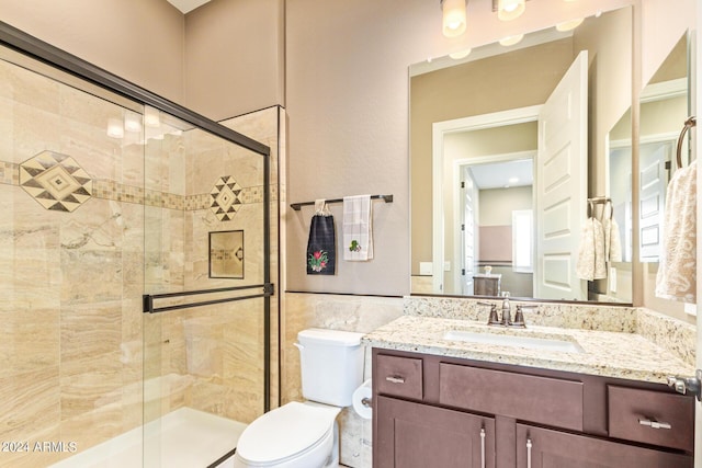 bathroom with walk in shower, vanity, and toilet