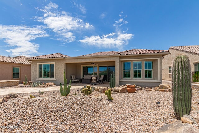 rear view of property featuring ceiling fan and a patio area