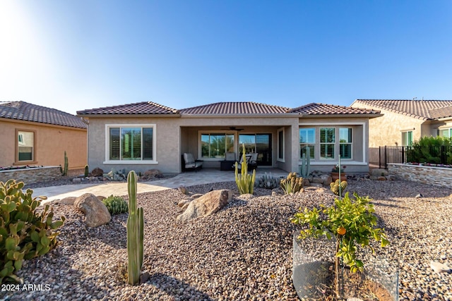 rear view of house featuring ceiling fan and a patio