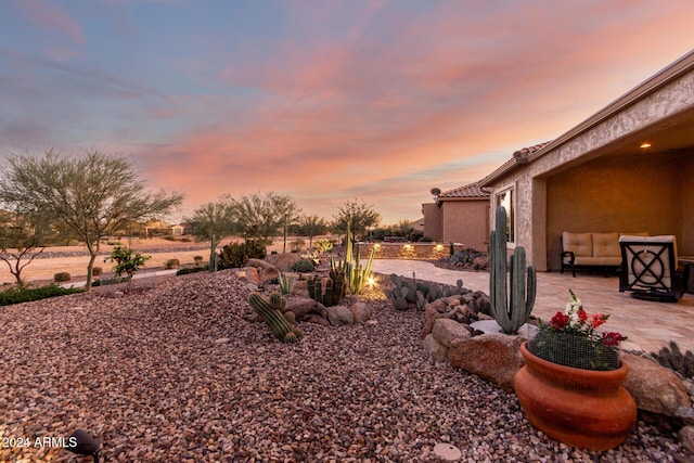 yard at dusk featuring a water view, a patio, and an outdoor hangout area