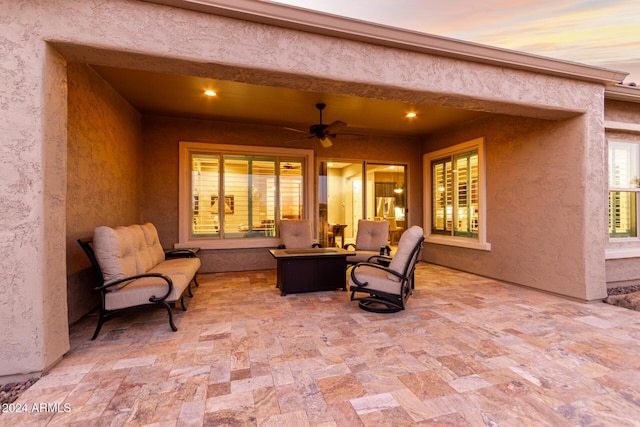 patio terrace at dusk with an outdoor living space and ceiling fan