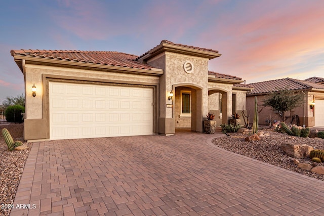 mediterranean / spanish-style home with a garage