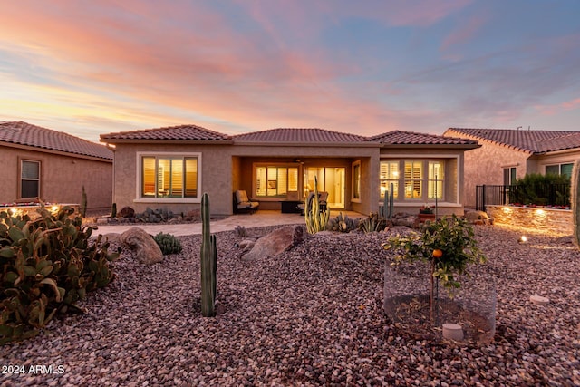 back house at dusk with a patio