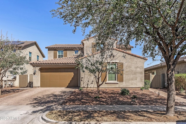 mediterranean / spanish home featuring driveway, a garage, a tile roof, fence, and stucco siding