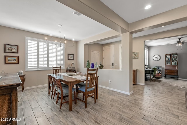 dining area featuring light wood finished floors, visible vents, baseboards, and ceiling fan with notable chandelier