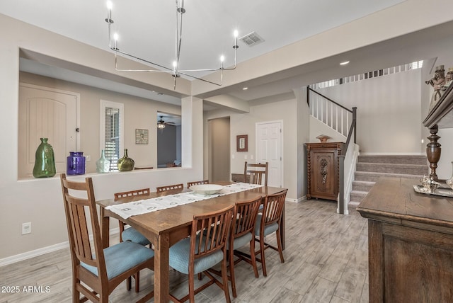 dining area featuring baseboards, stairway, visible vents, and light wood-style floors