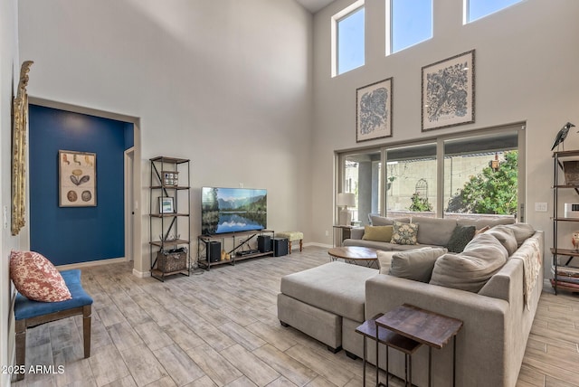 living area featuring wood tiled floor, plenty of natural light, and baseboards