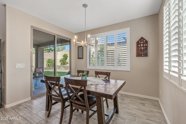 dining space with a notable chandelier, wood finish floors, and baseboards