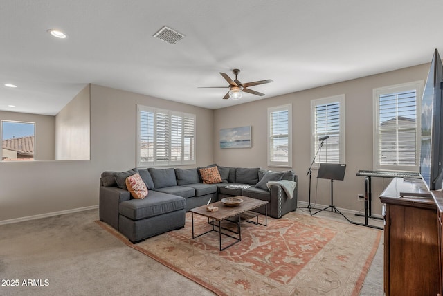 living room with a healthy amount of sunlight, visible vents, light carpet, and baseboards