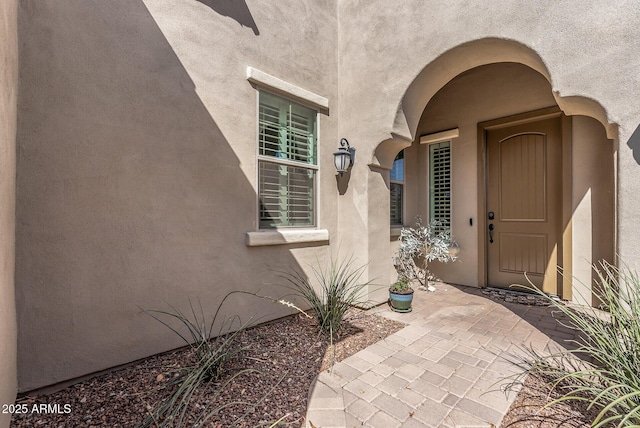 doorway to property featuring a patio and stucco siding