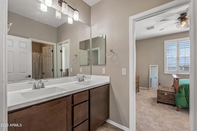 bathroom with double vanity, a ceiling fan, baseboards, and a sink