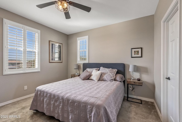 carpeted bedroom with multiple windows, ceiling fan, and baseboards