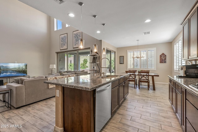 kitchen with wood finish floors, a sink, visible vents, dark brown cabinets, and dishwasher