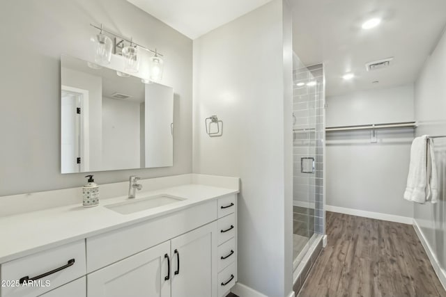 bathroom featuring a shower with door, vanity, and hardwood / wood-style floors