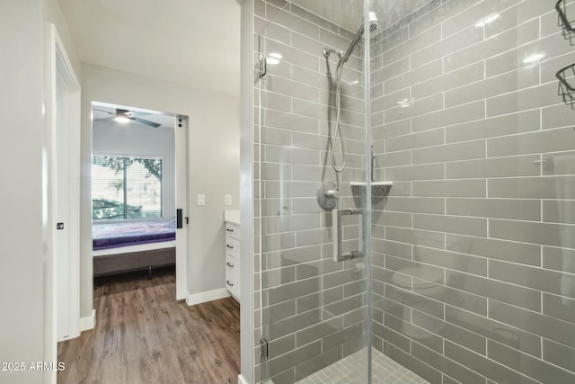 bathroom featuring ceiling fan, vanity, an enclosed shower, and hardwood / wood-style floors