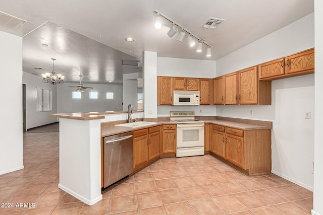 kitchen with light tile patterned floors, sink, kitchen peninsula, white appliances, and ceiling fan with notable chandelier