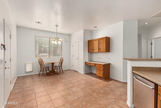 kitchen featuring dishwasher, built in desk, and light tile patterned floors