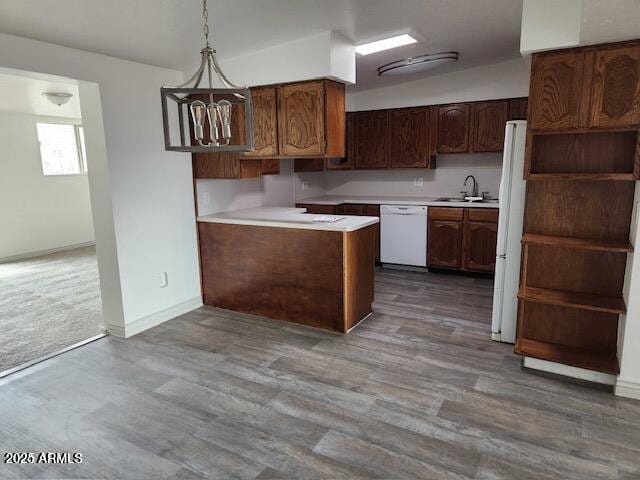 kitchen featuring dark brown cabinetry, sink, wood-type flooring, pendant lighting, and white appliances