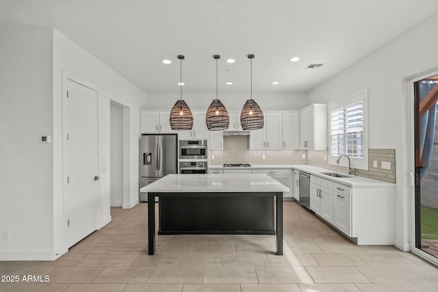 kitchen featuring visible vents, backsplash, appliances with stainless steel finishes, white cabinetry, and a sink