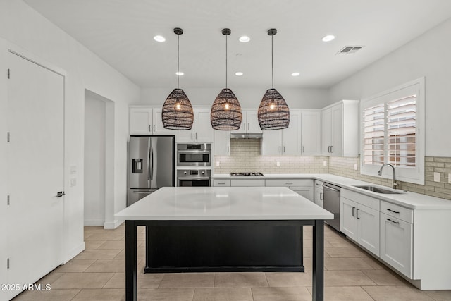 kitchen featuring visible vents, a sink, stainless steel appliances, white cabinetry, and backsplash