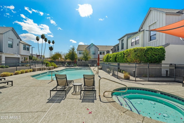 community pool featuring a patio area, a residential view, a hot tub, and fence