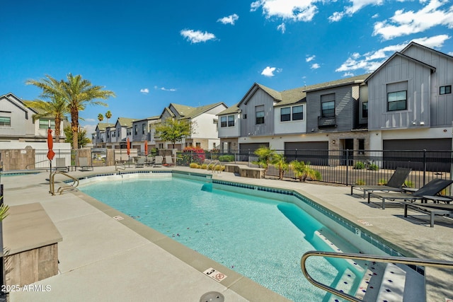 pool with a residential view, a patio, and fence