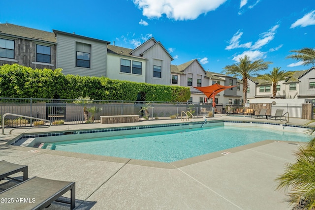 pool featuring a residential view, a patio, and fence