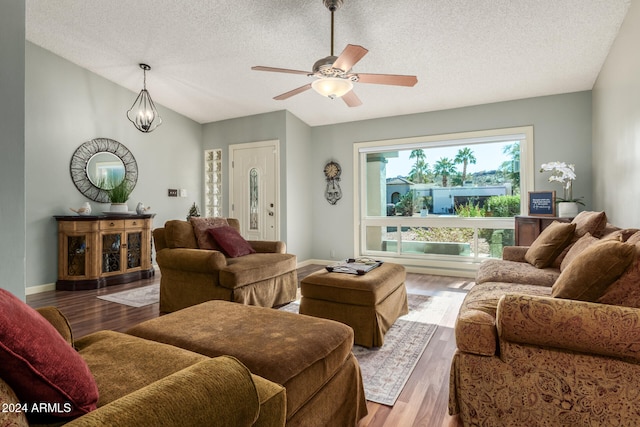 living room with ceiling fan, wood-type flooring, a textured ceiling, and vaulted ceiling