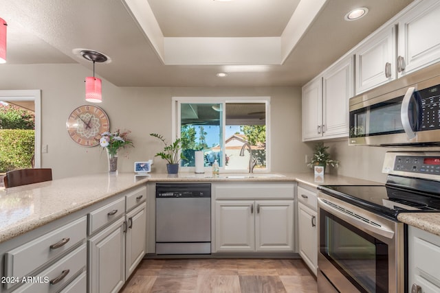 kitchen with a wealth of natural light, white cabinetry, sink, and appliances with stainless steel finishes