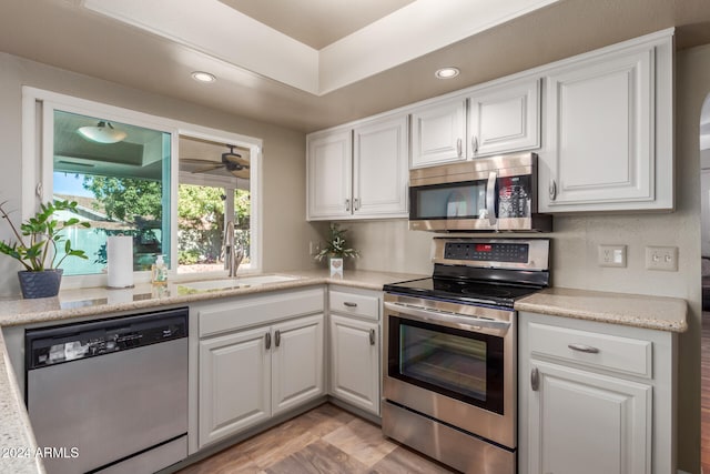 kitchen featuring white cabinetry, sink, appliances with stainless steel finishes, and light hardwood / wood-style flooring