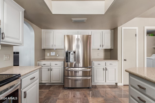 kitchen with white cabinets, light stone countertops, and stainless steel refrigerator with ice dispenser