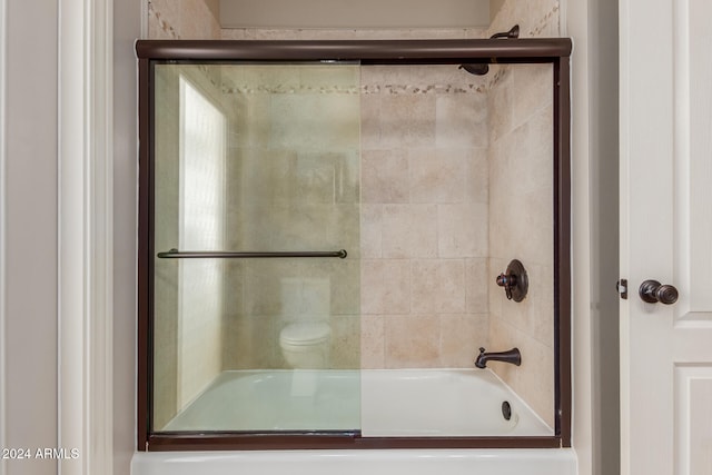 bathroom with combined bath / shower with glass door