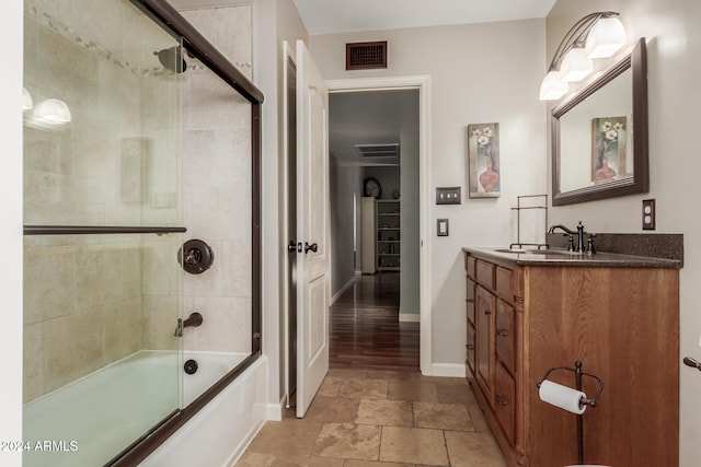 bathroom with hardwood / wood-style floors, vanity, and shower / bath combination with glass door