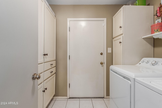 laundry room with washer and dryer, cabinets, and light tile patterned floors