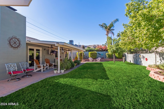 view of yard featuring ceiling fan, french doors, and a patio