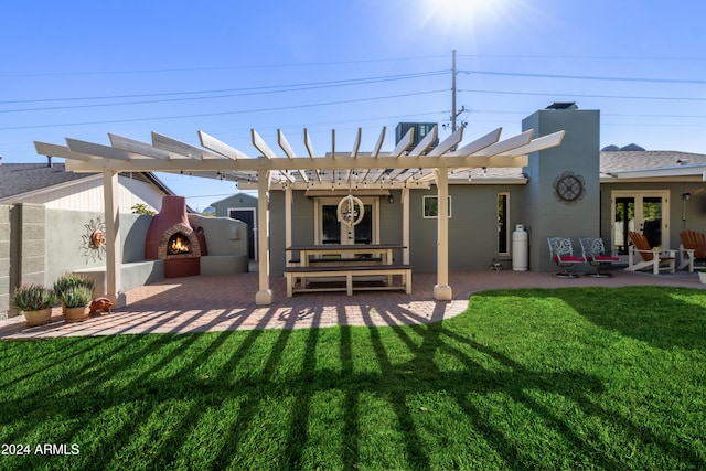 back of house with a pergola, a patio area, a yard, and an outdoor fireplace