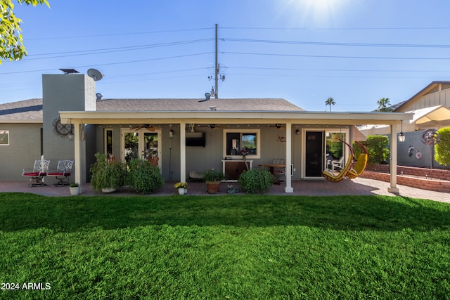 rear view of property with a yard, ceiling fan, and a patio area